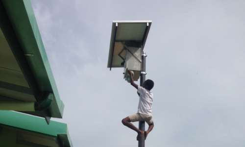Boy climbs a light post